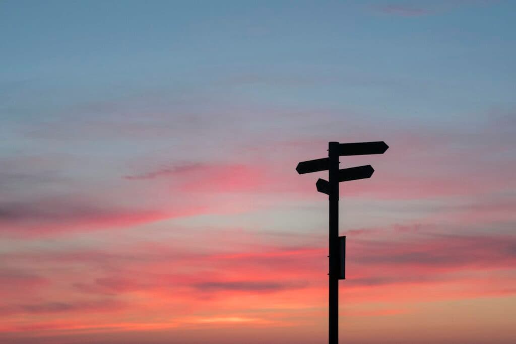 Silhouette d'un panneau de signalisation routière au coucher du soleil, symbole d'un changement de direction professionnelle