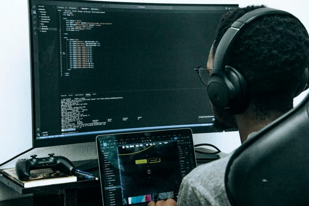 Jeune professionnel africain travaillant sur un ordinateur avec un casque audio, illustrant les métiers du numérique en Afrique de l'Ouest